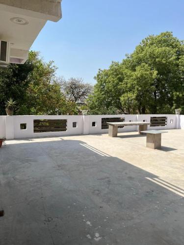 AyodhyaShri SeetaRam Home Stay Near Shri Ram Janmabhoomi Mandir Ayodhya的两个公园长椅,坐在白色围栏旁边