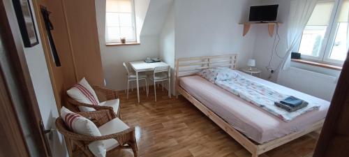 Dolní BeřkoviceUbytování U Tajčů的一间小卧室,配有一张床和一把椅子