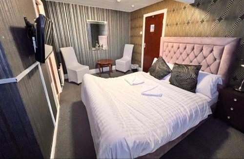 布莱克浦The oxford Hotel的卧室配有一张带两把椅子的白色大床