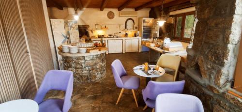 凯勒里瓦迪Mykonian Iros Suites & Villas的厨房配有紫色椅子、桌子和柜台