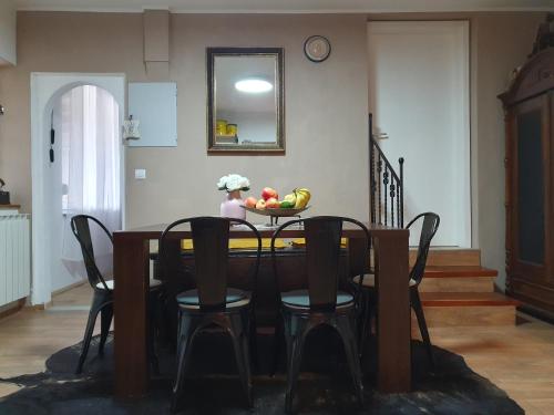 托尔明Apartment with Terrace Nona Pavla的桌子上摆放着椅子,还有一碗水果