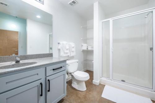 堪萨斯城3BR 2BA Luxury Historic Loft With Gym by ENVITAE的白色的浴室设有卫生间和淋浴。