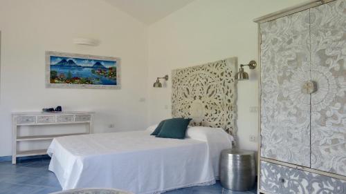 阿兰奇湾城Macciuneddu Country Retreat的一间白色卧室,配有一张床和一个梳妆台