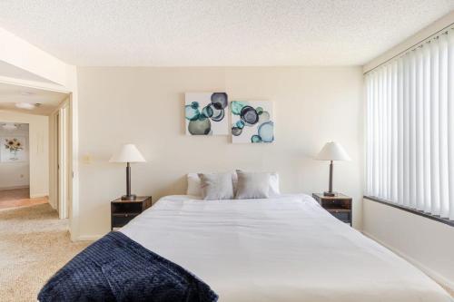 阿林顿2BR Serene Executive Retreat with Balcony的卧室配有一张白色大床和两盏灯。