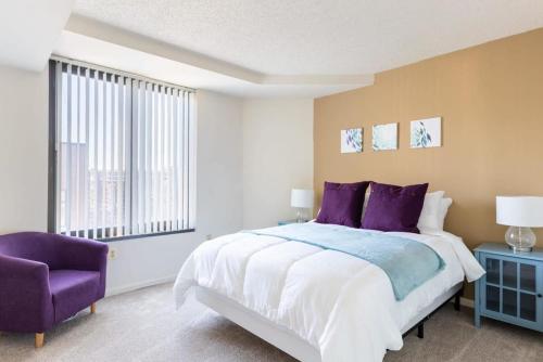 阿林顿2BR Serene Executive Retreat with Balcony的一间卧室配有一张大床和一张紫色椅子