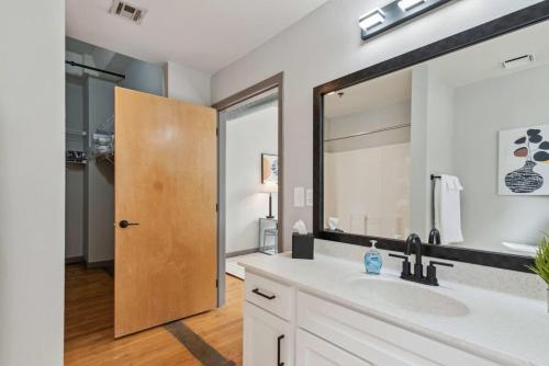 堪萨斯城Spacious & Elegant 2BR Downtown Retreat的一间带水槽和大镜子的浴室