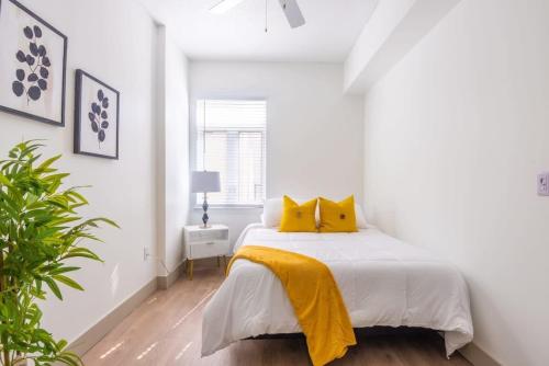 夏洛特3BR Premium Downtown Apartment with Office & Gym的白色卧室配有黄色枕头的床