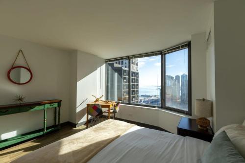 芝加哥Ultimate 3BR Luxury Suite near Navy Pier with Gym & Pool by ENVITAE的一间卧室设有一张床和一个大窗户