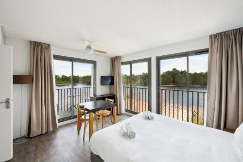拉特斯特德布赫拉特斯特全套房酒店 - 阿卡雄湾的酒店客房设有一张床、一张书桌和窗户。