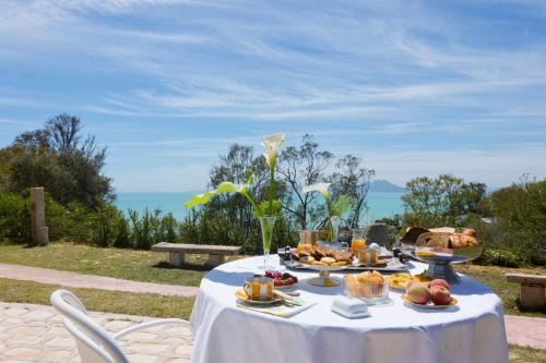 西迪·布·赛义德Si Brahim studio piscine, Sidi Bou Saïd的一张桌子,上面有食物,后面有海洋