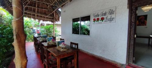 吉汶瓦Santa Rita lodge的一间在房间内配有桌椅的餐厅