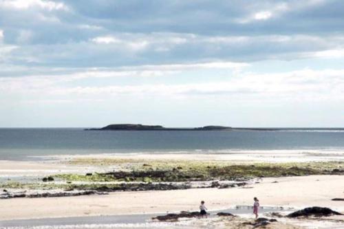 韦克斯福德Islands View的两人站在海滩上,带冲浪板