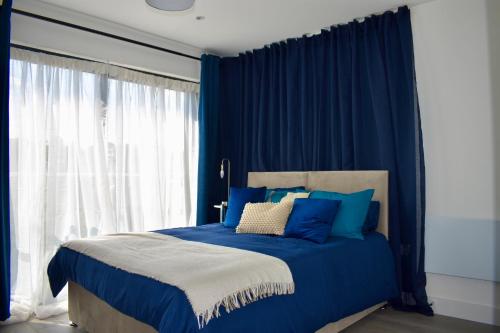 赫默尔亨普斯特德Hemel Apartments- Riverside Retreat的蓝色卧室,配有蓝色窗帘