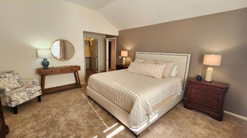 哈伯斯普林斯Birchwood Dream的一间卧室配有一张床、一把椅子和镜子