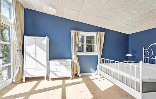 斯文堡Amazing Home In Svendborg With Wifi的蓝色的幼儿园,有白色的婴儿床和蓝色的墙壁