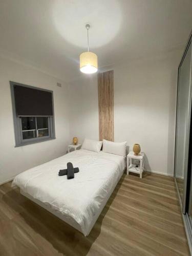 悉尼Close to city 2 Bedroom House Surry Hills的一间卧室配有一张大床,上面有黑色的十字架