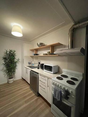 悉尼Close to city 2 Bedroom House Surry Hills的厨房配有炉灶和微波炉。