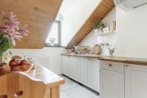 克拉科夫Pokoje Gościnne Cheval的厨房配有白色橱柜和木制天花板