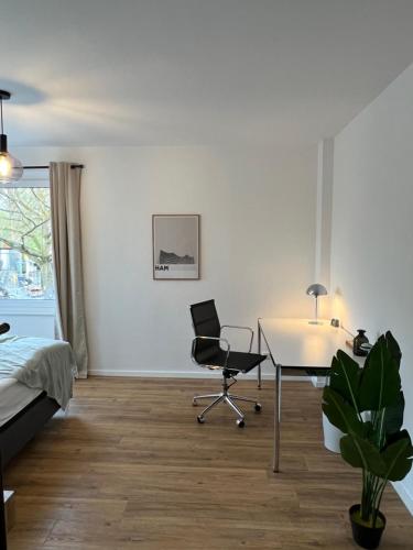 汉堡Business Apartment Kranich: 3 Zimmer, Top Infrastrukturlage HH Langenhorn, Nähe Airport的一间卧室配有书桌、椅子和床