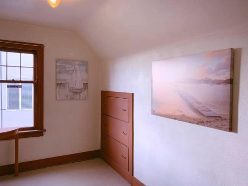西雅图Seattle Urban Village- Shasta的卧室配有梳妆台,墙上挂有绘画作品