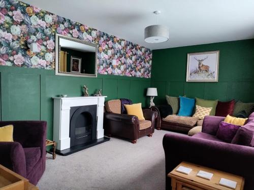 莫顿因马什Woldsend的客厅设有绿色墙壁、沙发和壁炉