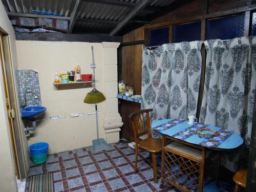 丰盛港Warisan Homestay Anjung的带厨房的客房内的桌椅