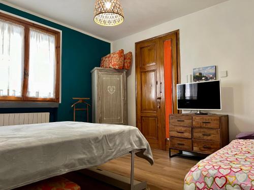 维亚雷焦Appartamento piano terra centro的一间卧室配有一张床,梳妆台上配有电视