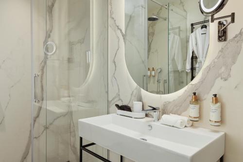 蒂瓦特Porto Palace Suites的白色的浴室设有水槽和淋浴。