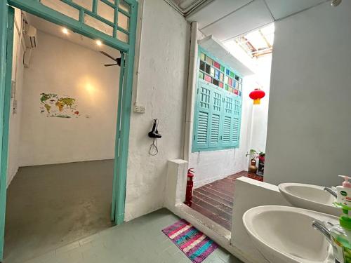 马六甲Melaka jonker street kids friendly guesthouse Malacca的一间带两个水槽和绿色门廊的浴室