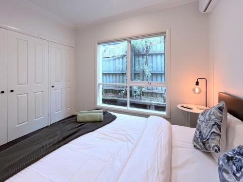Mont AlbertLuxury Designer Home Villa Surrey Hills的卧室配有白色的床和窗户。