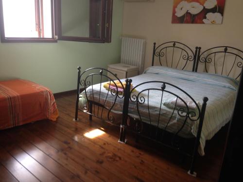 苏尔博B&B La Stella的一间卧室配有一张床,铺有木地板