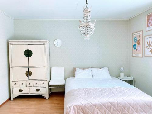 波尔沃Expe Finland的一间卧室配有一张床、梳妆台和吊灯。