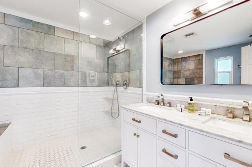 迈尔斯堡Gecko Getaway的带淋浴、两个盥洗盆和镜子的浴室