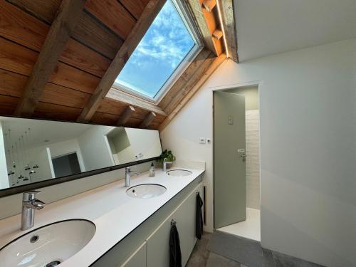 滨海利翁LES BRIQUES的一间带两个盥洗盆的浴室和一个大窗户