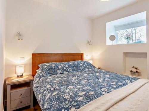 沃顿安德埃奇1 Bed in Wotton-under-Edge 91936的一间卧室配有一张带蓝色和白色床单的床。