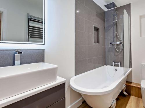 沃顿安德埃奇1 Bed in Wotton-under-Edge 91936的浴室配有盥洗盆、卫生间和浴缸。