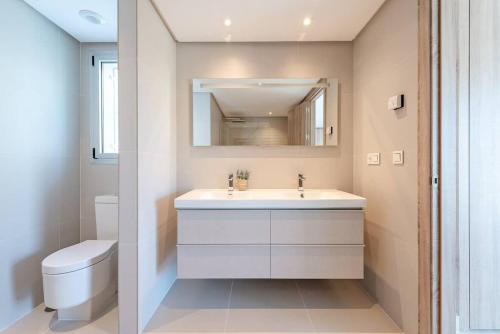 贝纳阿维斯LUXURY PENTHOUSE MARBELLA WIFI POOLS NETFLIX GOLF的浴室配有白色水槽和卫生间。