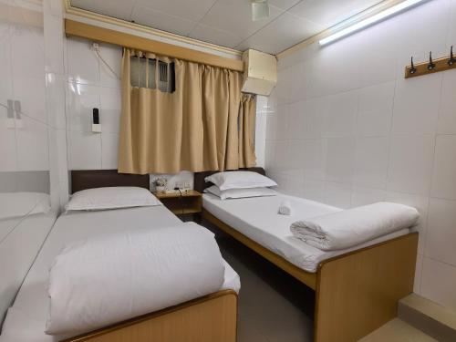 香港景士迪宾馆的小房间设有两张床和窗户