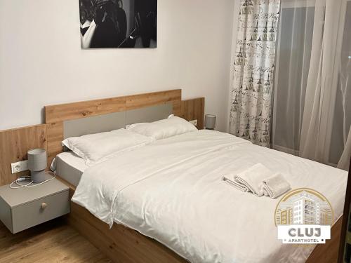克卢日-纳波卡Cluj Viva Aparthotel的一间卧室配有一张带白色床单的大床