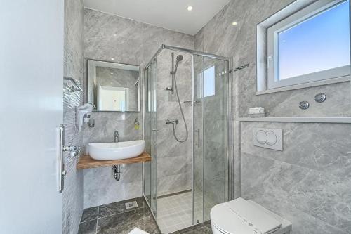 特罗吉尔特洛吉尔多瑞酒店的带淋浴、盥洗盆和卫生间的浴室