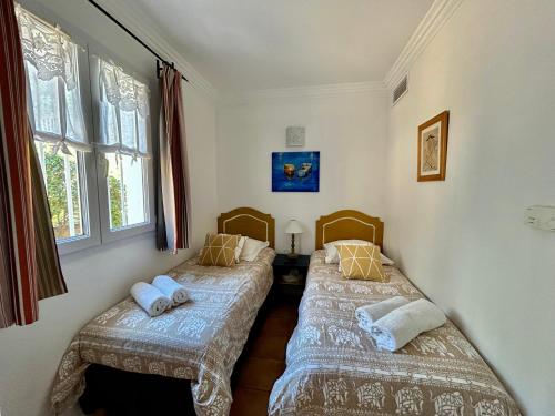 格里莫Les Restanques Cabrière 3024的带窗户的客房内的两张单人床