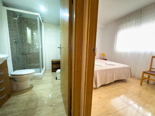 蒙特罗伊Acogedor apartamento cerca de la playa wifi y parking的浴室设有床、卫生间和窗户。