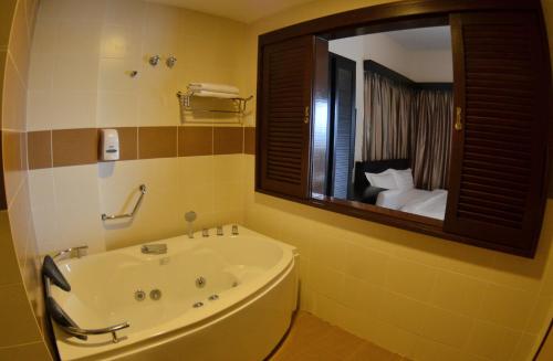 艾尔克如MySuite Studio Apartment Melaka Waterpark Resort的一间带浴缸和大镜子的浴室