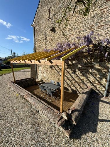 蓬托尔松Gîte de la petite tour的屋顶下带椅子的木甲板