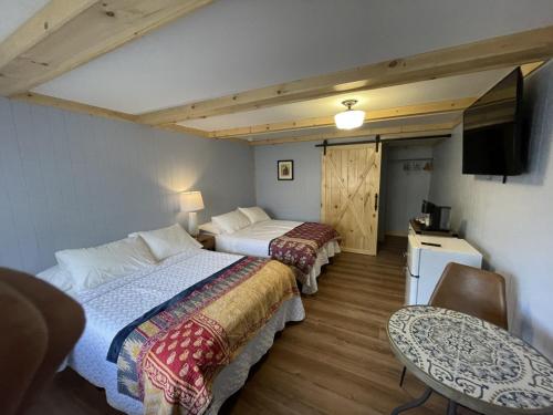 MarienvilleSweet Forest Breeze, A Cook Forest Inn的客房设有两张床、一张桌子和电视。