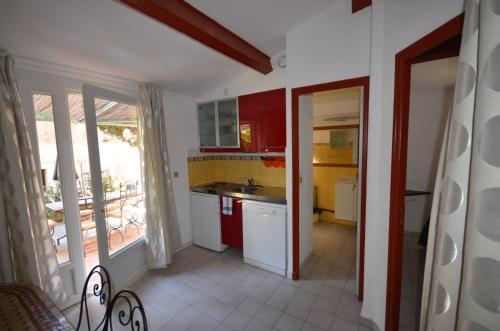 波克罗勒岛Le Clos des Galéjades的厨房配有红色和黄色的橱柜和水槽