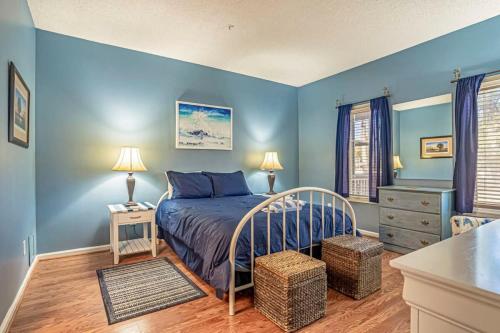 北默特尔海滩Teal lake 1311的一间拥有蓝色墙壁的卧室和一张位于客房内的床