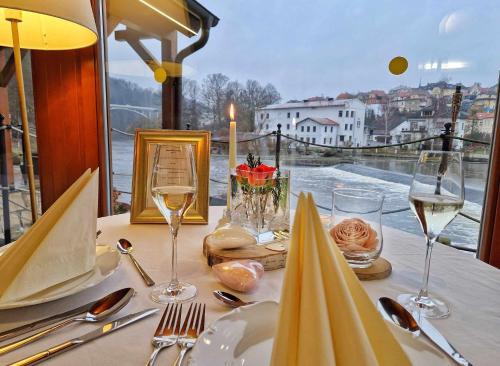 塔博尔ROMANTIK HOTEL ELEONORA的一张桌子,上面放着酒杯,享有水景
