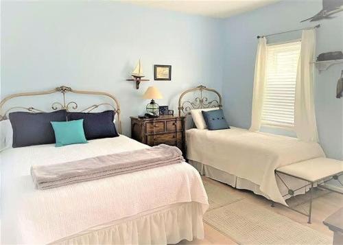 北默特尔海滩Teal Lake 212的一间卧室设有两张床、一把椅子和一个窗户。