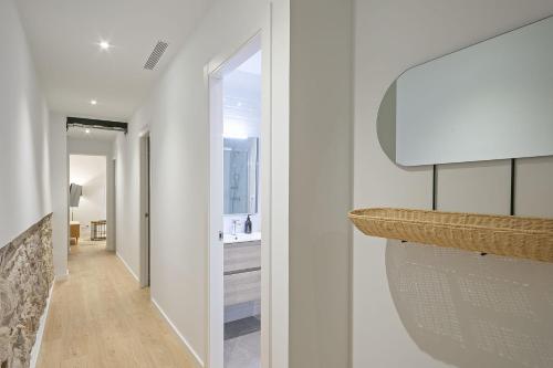 巴塞罗那Ola Living Diagonal Apartments的走廊设有白色的墙壁、水槽和镜子